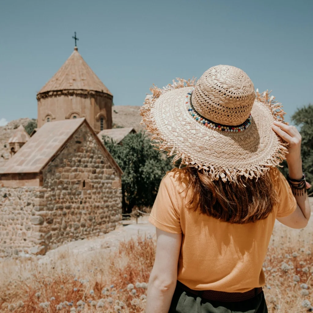 Woman in straw hat admiring historic stone building