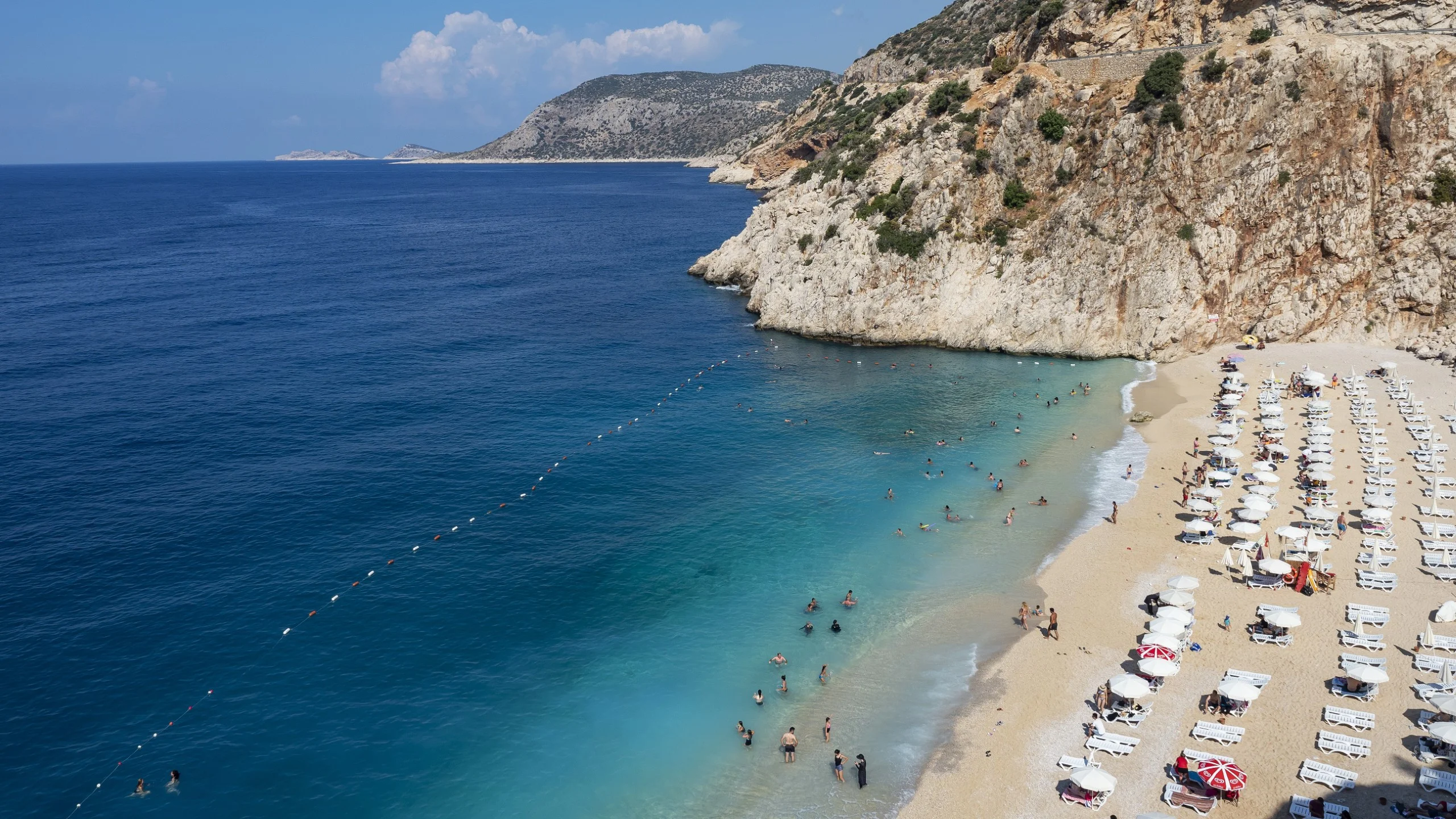 Aerial view of Kaputas Beach with turquoise water and sunbathers.