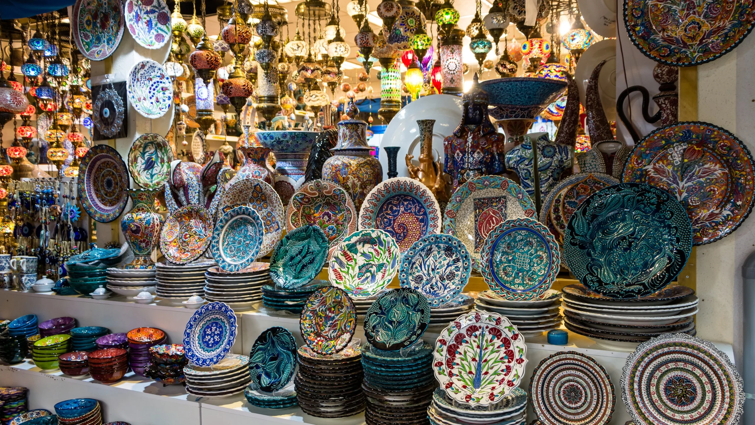 Colorful traditional ceramic plates on display at a market stall.