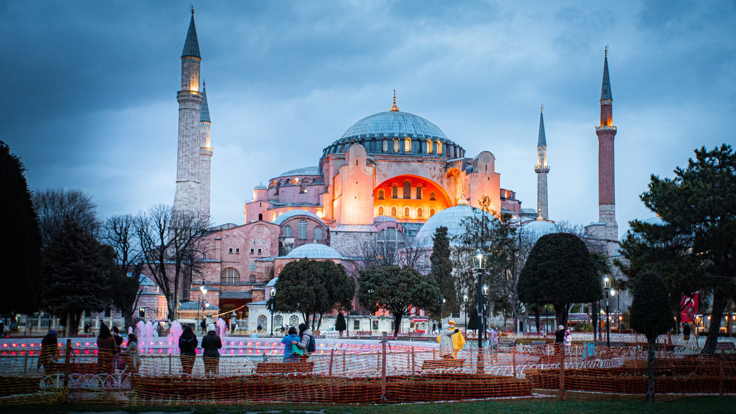 Hagia Sophia Mosque at dusk in Istanbul with illuminated domes and minarets.