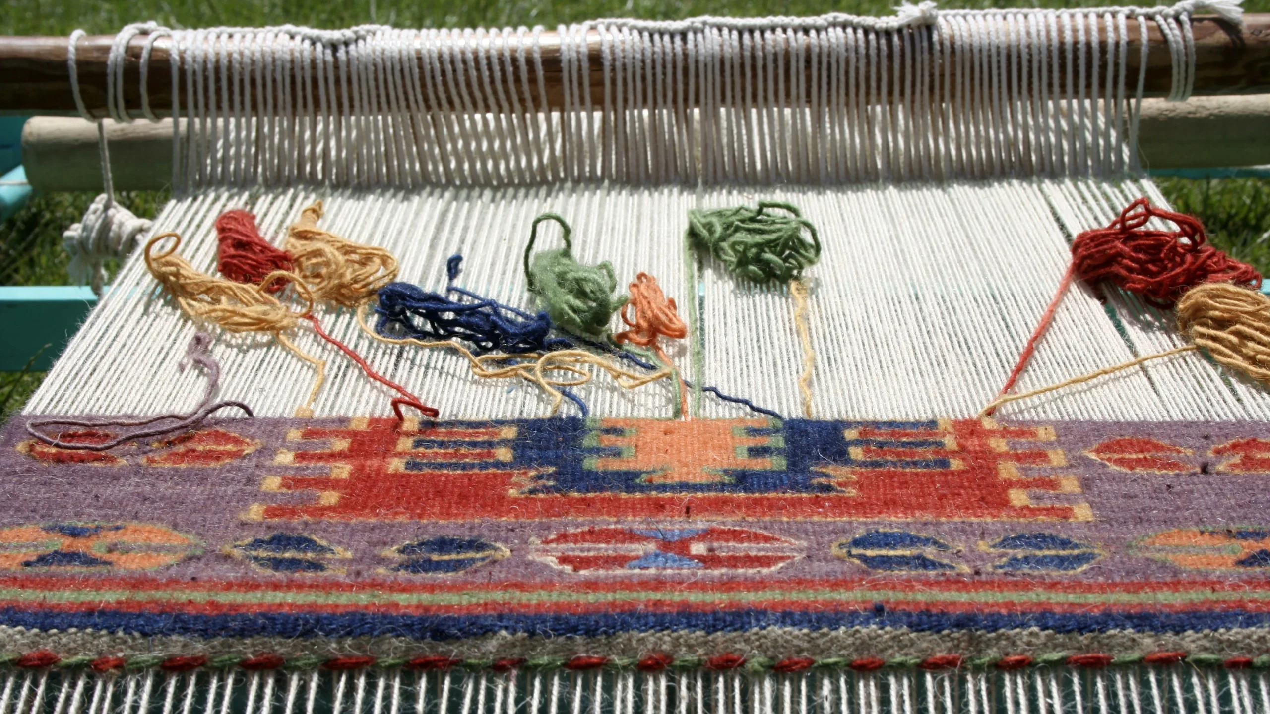 Traditional loom with colorful rug in progress at Luwian Travel.